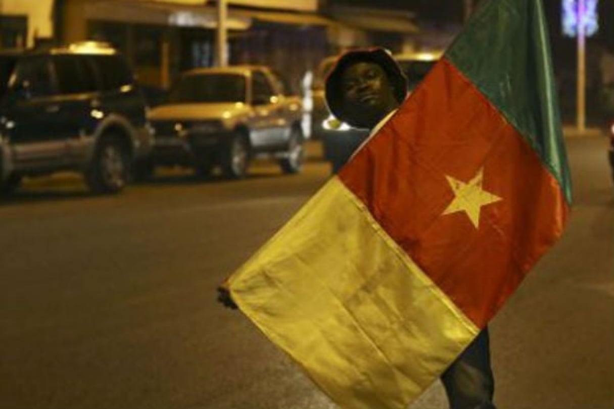 Un jeune homme tenant le drapeau du Cameroun. © Sunday Alamba/AP/SIPA