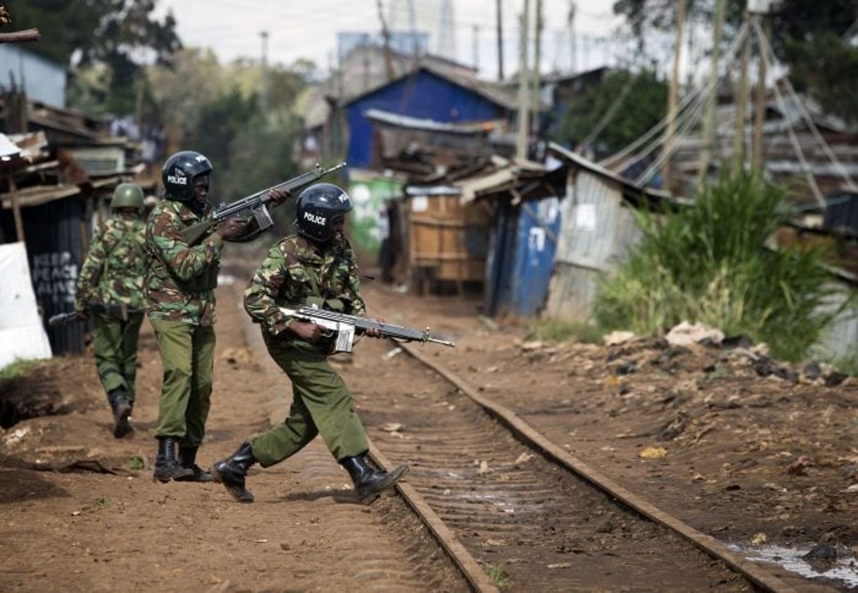 Des soldats en train de patrouiller, armes automatiques en mains, dans le bidonville de Kibera, à Nairobi. © Darko Bandic/AP/SIPA