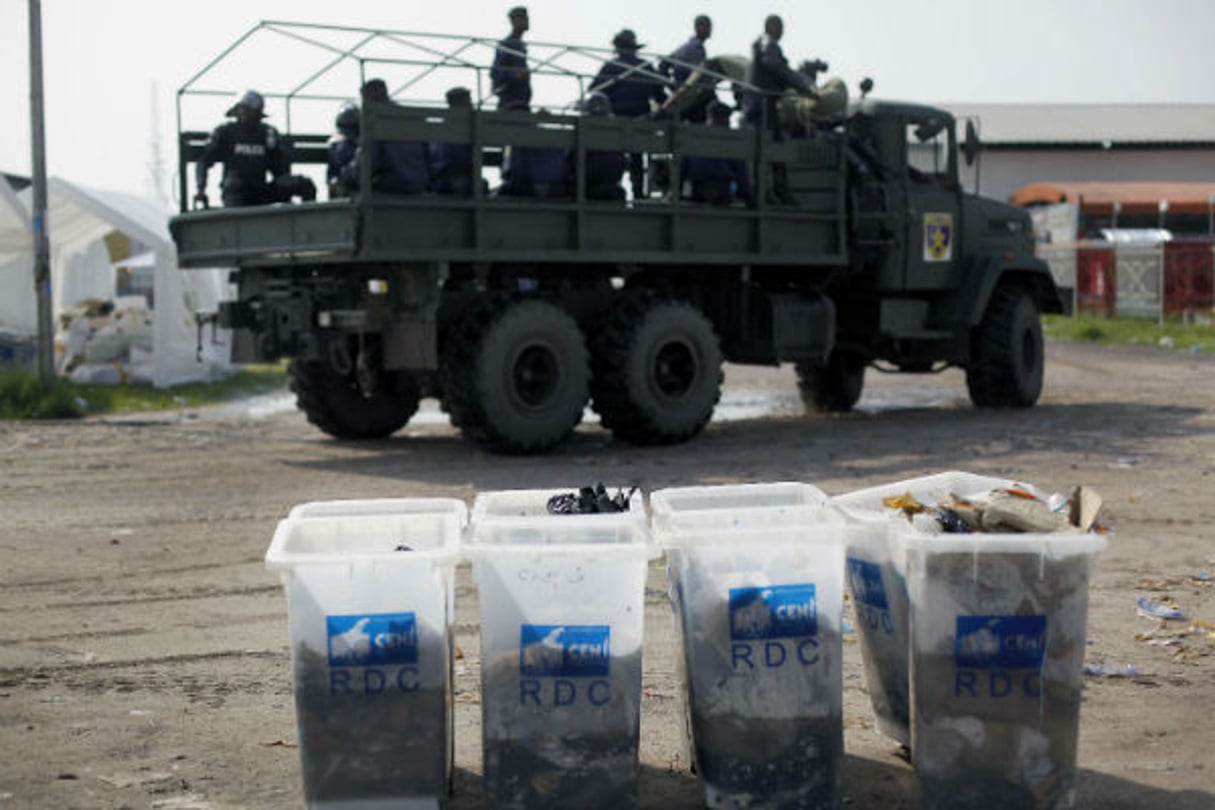 Des militaires passent près d’urnes électorales transformées en poubelles, après les élections de décembre 2011. © Jerome Delay/AP/SIPA