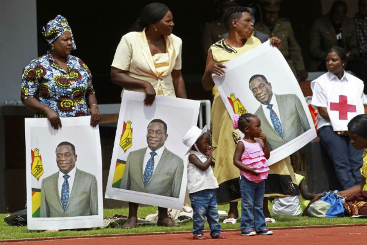 Des Zimbabwéens portent des portraits d’Emmerson Mnangagwa lors de l’investiture, ce vendredi 24 novembre 2017 à Harare. © Tsvangirayi Mukwazhi/AP/SIPA