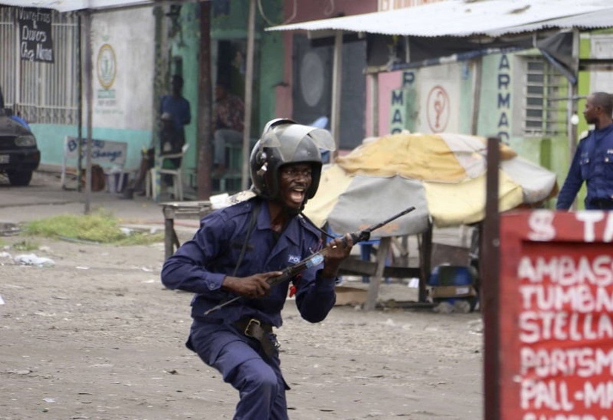 Un policier congolais en train de poursuivre des manifestants à Kinshasa, le dimanche 31 décembre 2017. © John Bompengo/AP/SIPA