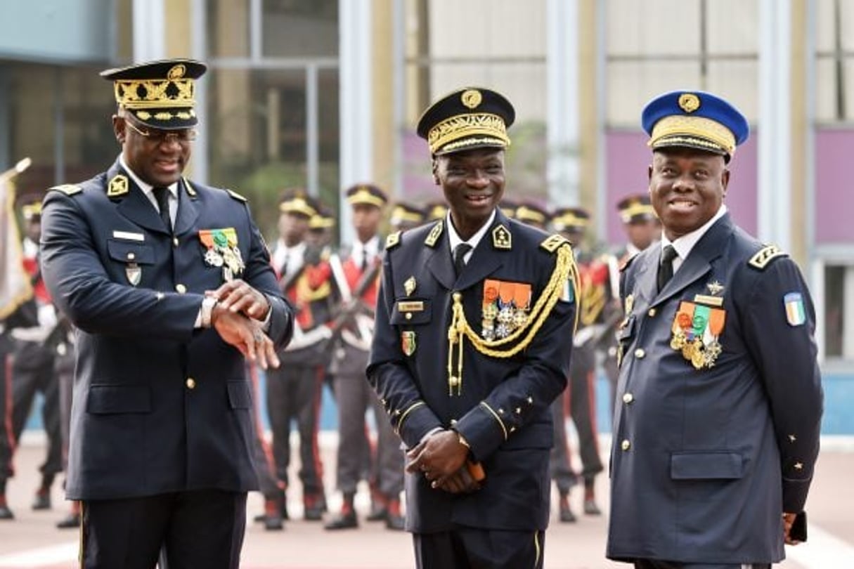 Sékou Touré entouré du DG de la police nationale, Youssouf Kouyaté (à g.), et du commandant supérieur de la gendarmerie, Nicolas Kouakou, lors de la cérémonie des vSux au palais présidentiel, le 4 janvier. © SIA KAMBOU/AFP