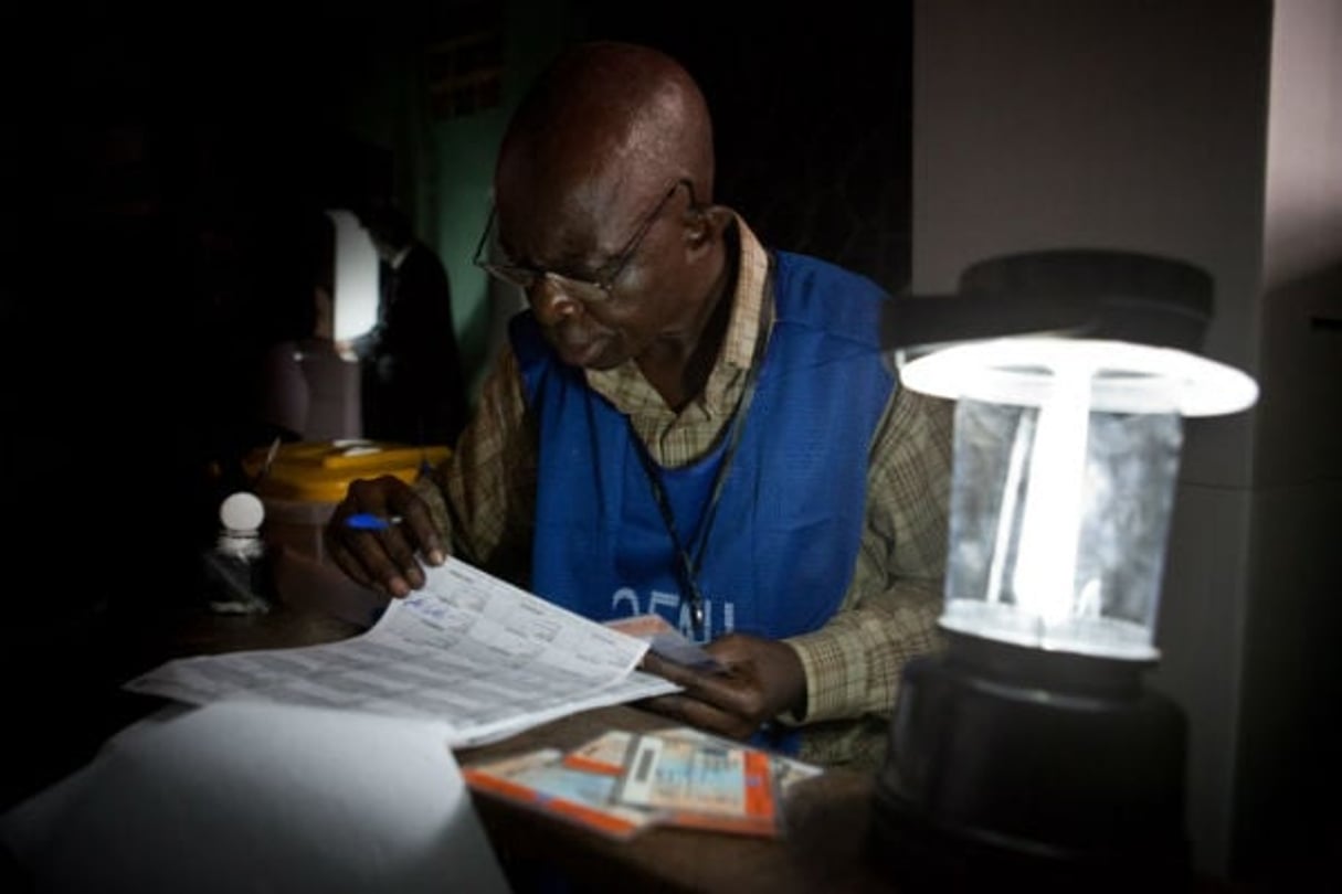 Un agent électoral vérifie la liste des votants à Kinshasa, le 28 novembre 2011. © Gwenn Dubourthoumieu pour Jeune Afrique