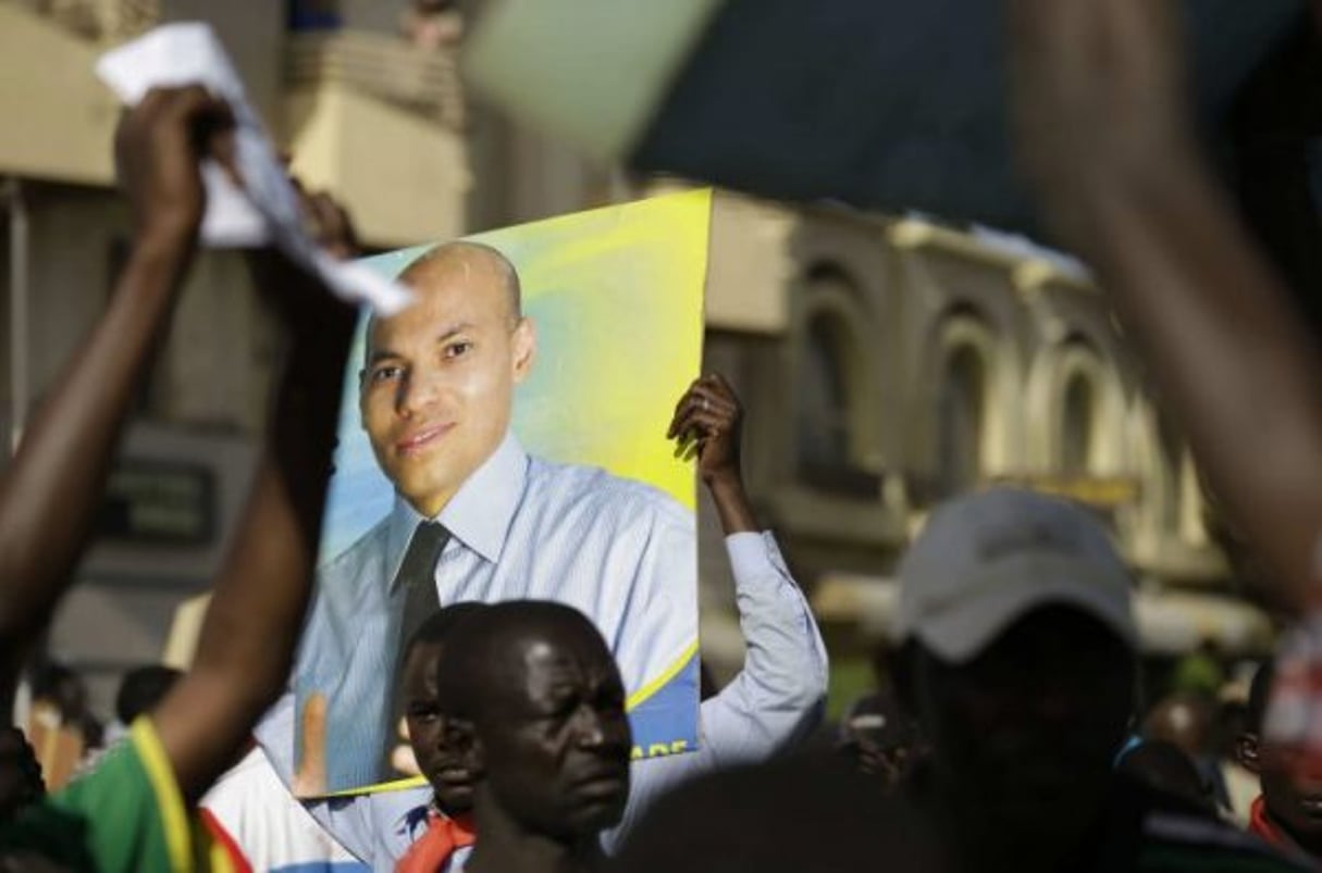 Un manifestant brandit un poster de Karim Wade, dans les rues de Dakar, en avril 2013. © Rebecca Blackwell/AP/SIPA
