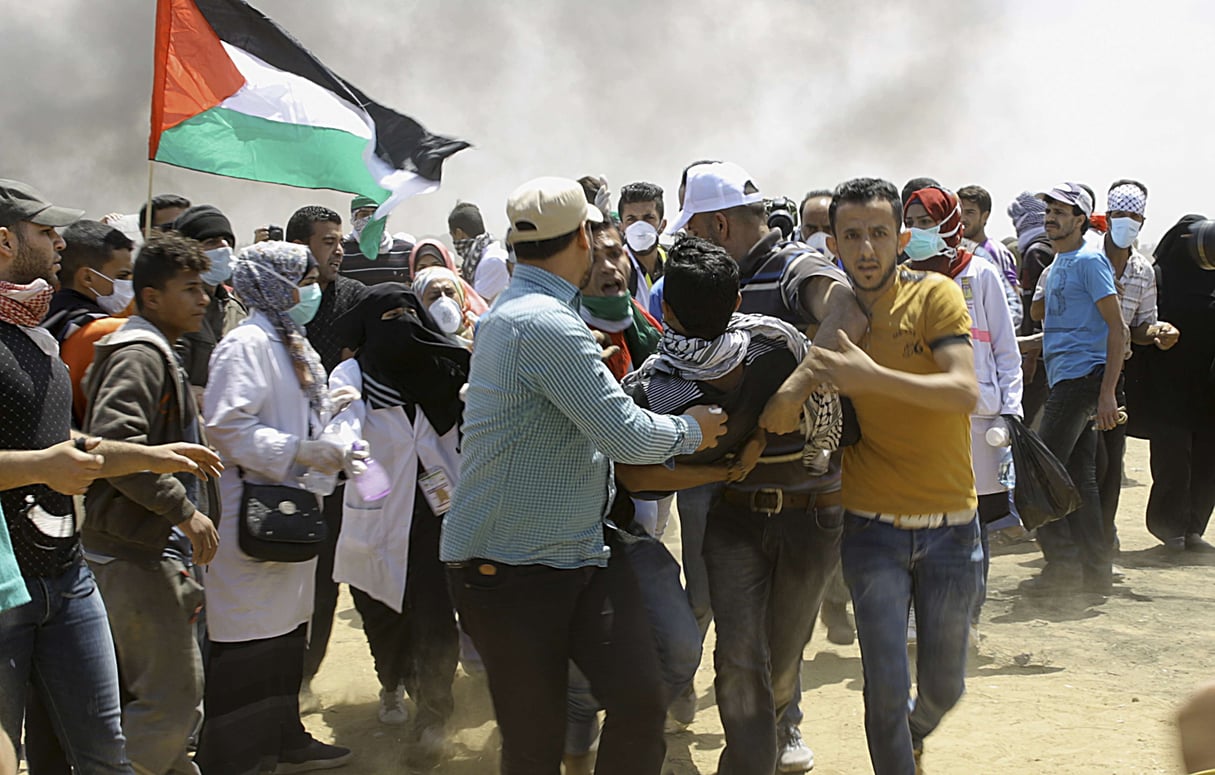 Des manifestants palestiniens évacuent un jeune blessé près de la frontière israélienne, à l’est de Khan Younis, dans la bande de Gaza, lundi 14 mai 2018, peu avant l’inauguration de l’ambassade des Etats-Unis à Jérusalem. © Adel Hana/AP/SIPA