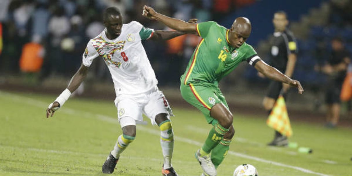 Le Sénégalais Cheikhou Kouyaté (g.) à la lutte avec le Zimbabwéen Willard Katsande, lors d’un match de CAN, le 19 janvier 2017 à Franceville, au Gabon. © Sunday Alamba/AP/SIPA