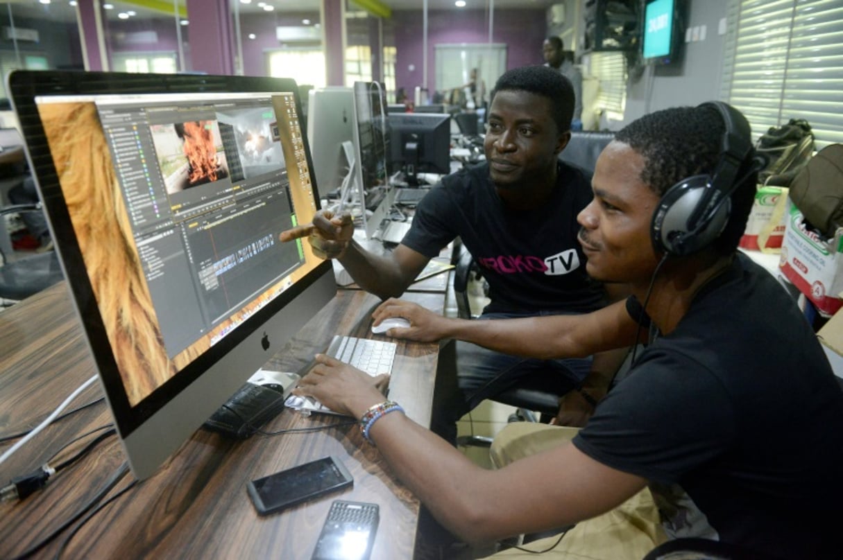 Les monteurs vidéo David Adeoti (gauche) et Jolaosho Oladimeji (droite) dans les locaux de Iroko tv, pionnier de la distribution de contenus en ligne, à Lagos, le 27 mars 2014. © AFP/ Archives / PIUS UTOMI EKPEI