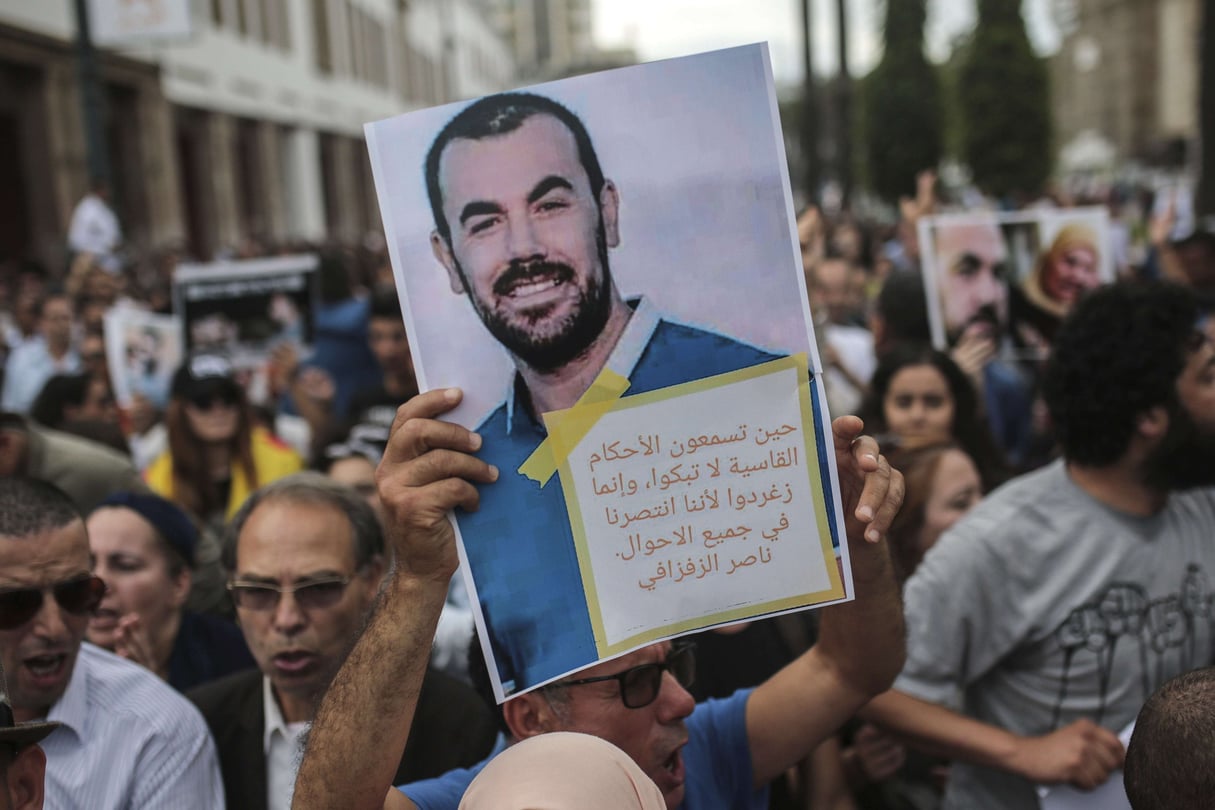 Un manifestant soulève un portrait du meneur du Hirak Nasser Zefzafi, lors d’une marche de protestation contre le verdit du procès. (image d’illustration) © Mosa’ab Elshamy / AP SIPA