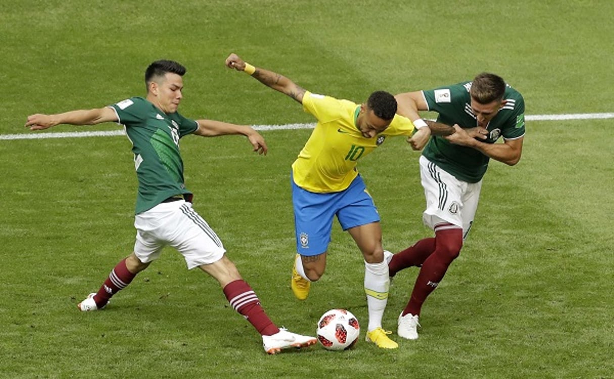 Le joueur brésilien Neymar pris en tenaille entre deux défenseurs mexicains, le 2 juillet 2018. © Sergei Grits/AP/SIPA