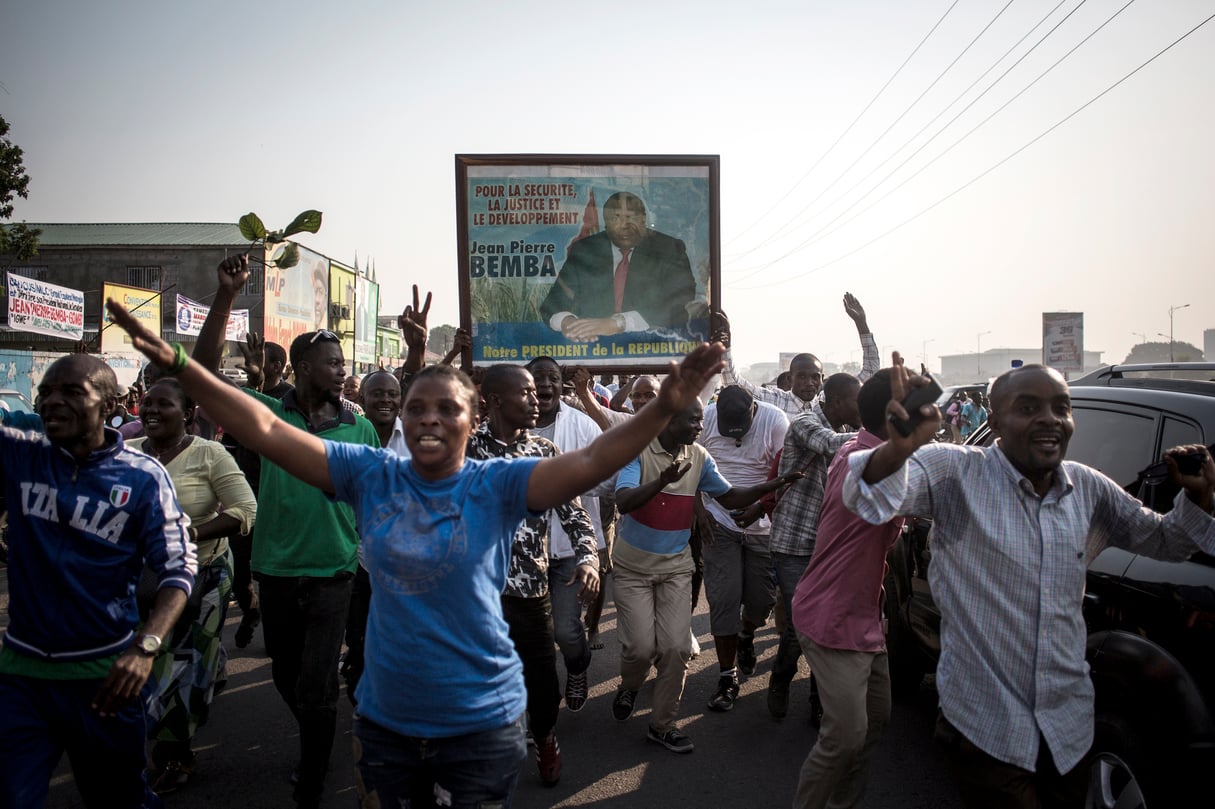 3eme photo Supporters of Jean-Pierre Bemba hold his poster as they march to celebrate in Kinshasa on June 8, 2018 after the news that the International war crimes judges in The Hague acquitted the former Congolese vice president on appeal, overturning an 18-year sentence for war crimes committed in the Central African Republic.The Hague-based ICC's appeal judges said Bemba was "erroneously" convicted for specific criminal acts. Trial judges were also wrong in their finding that Bemba could in fact prevent crimes being committed by his MLC troops, they ruled. In 2016, the ICC's judges had unanimously found Bemba -- nicknamed "Miniature Mobutu" -- guilty on five charges of war crimes and crimes against humanity for abuses committed by his troops during a five-month rampage in the neighbouring CAR. / AFP PHOTO / JOHN WESSELS &copy; JOHN WESSELS/AFP