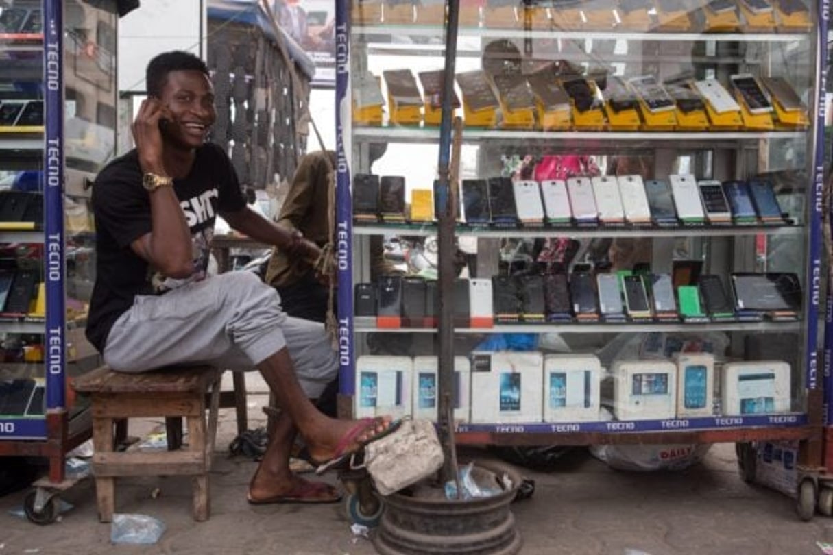 Un homme vend des téléphone portable dans le quartier commercial de Ganhi à Cotonou, au Bénin, le 26 février 2016. © Gwenn Dubourthoumieu pour J.A.
