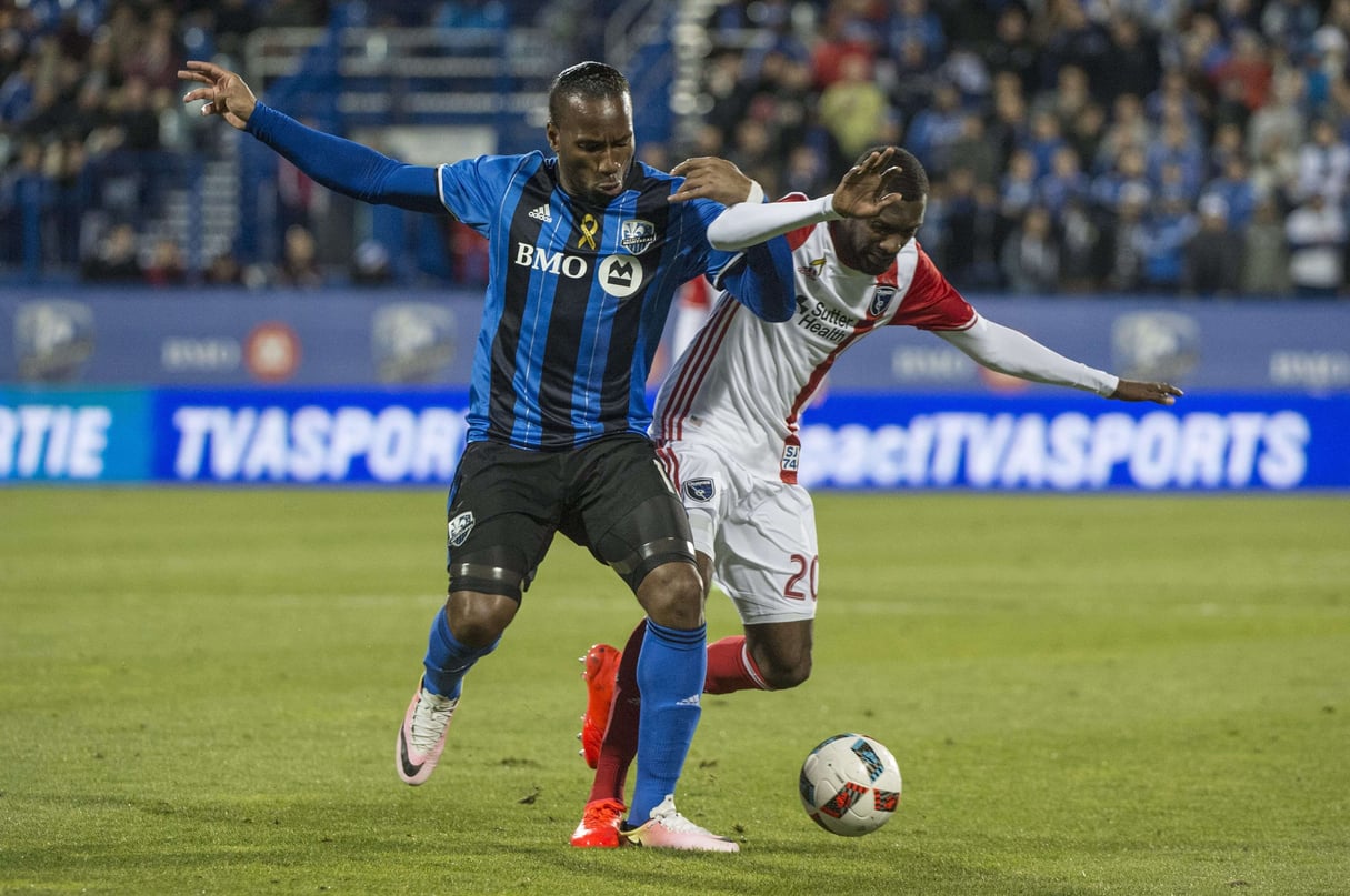 L'attaquant de l'Impact Montréal Didier Drogba, à gauche, et le défenseur des San Jose Earthquakes, Shaun Francis, s'affrontent pour le ballon lors de la deuxième moitié d'un match de soccer de la MLS, le mercredi 28 septembre 2016 à Montreal. &copy; Paul Chiasson/AP/SIPA