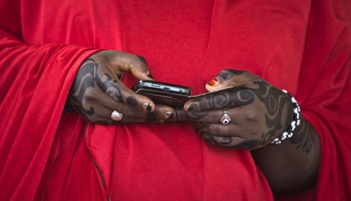 Une femme haoussa regarde son smartphone, pendant les élections nigérianes de mars 2015. © Ben Curtis/AP/SIPA