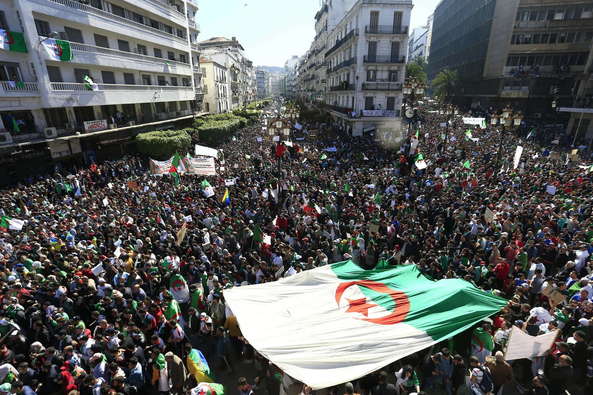 Les Algériens portent un drapeau national géant lors d’une manifestation à Alger, en Algérie, le vendredi 15 mars 2019 (photo d’illustration). © Toufik Doudou/AP/SIPA