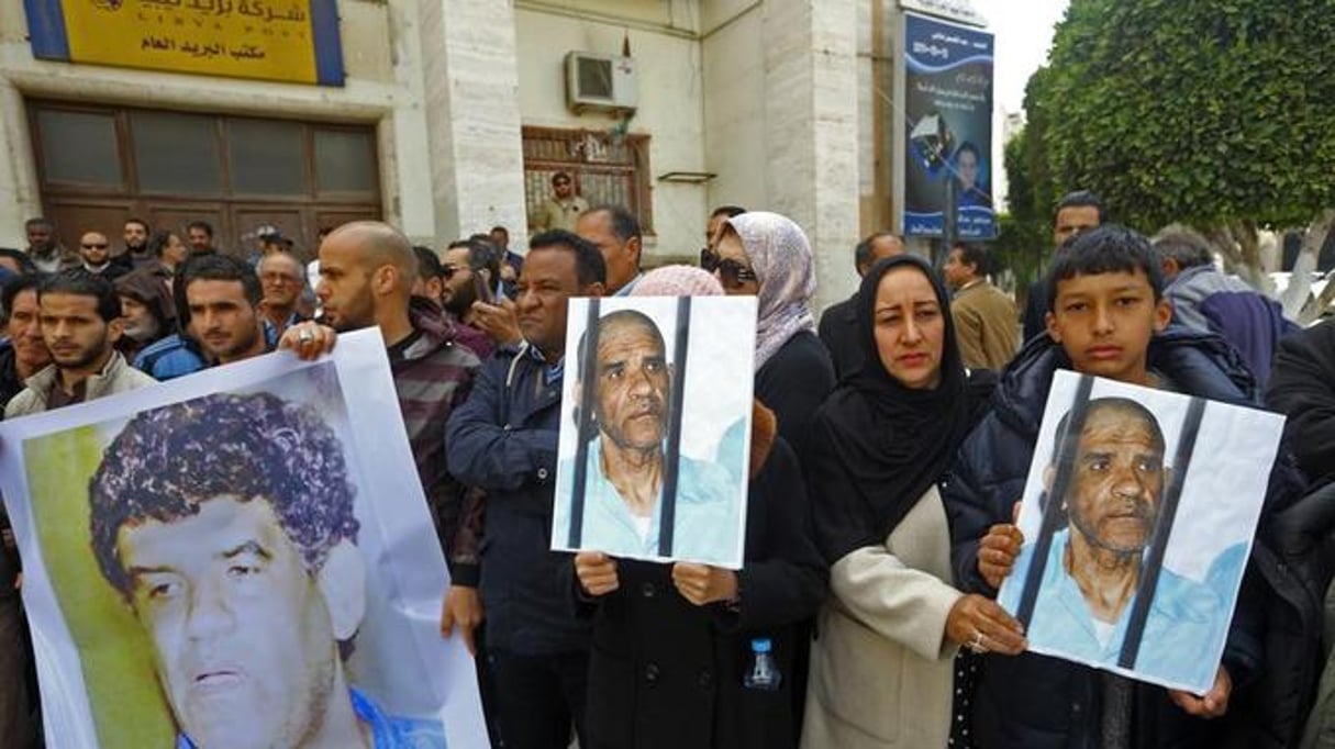 Les manifestants ont brandi des photos d’Abdallah al-Senoussi derrière des barreaux et des pancarte. © Mahmud Turkia / AFP
