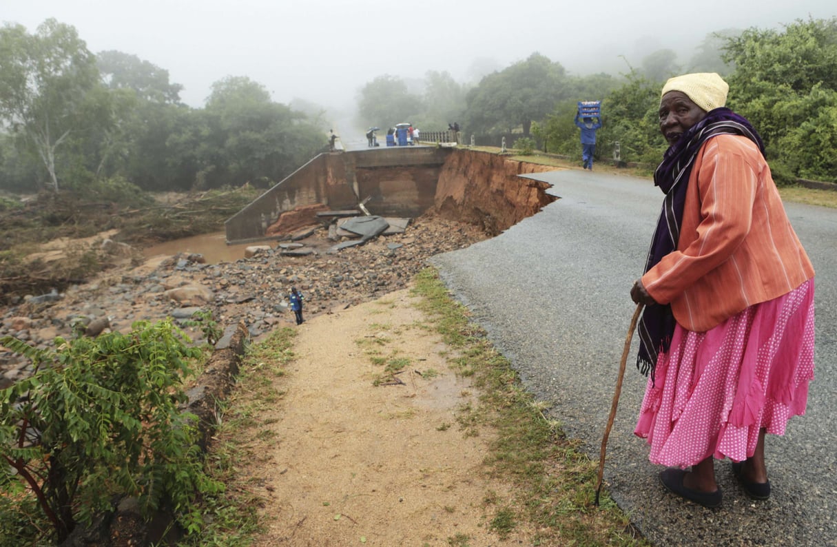 Une vieille dame traverse un pont délabré à Chimanimani, au Zimbabwe après le passage du cyclone Idai. &copy; AP Photo/Tsvangirayi Mukwazhi