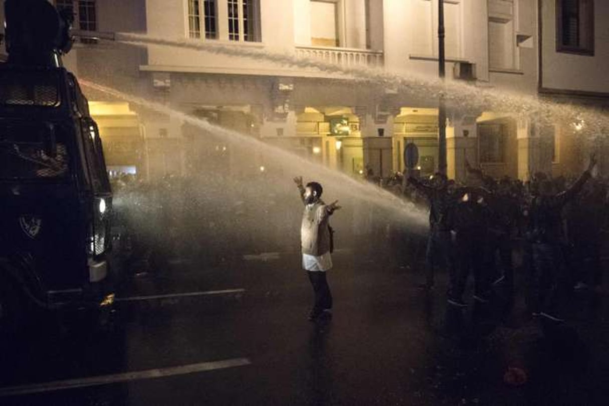 Un manifestant marocain lève les bras devant les canons à eau utilisés par la police lors d’une manifestation dans la capitale Rabat, le 24 mars 2019. © FADEL SENNA / AFP