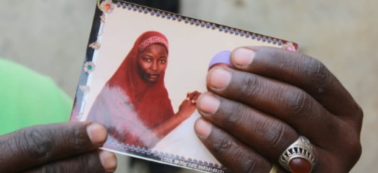 Le père d’Hauwa Musa Maina présente le 12 avril 2019 à Chibok au Nigeria, une photo de sa fille, enlevée il y a cinq ans par les jihadistes de Boko Haram. © Audu Ali MARTE / AFP