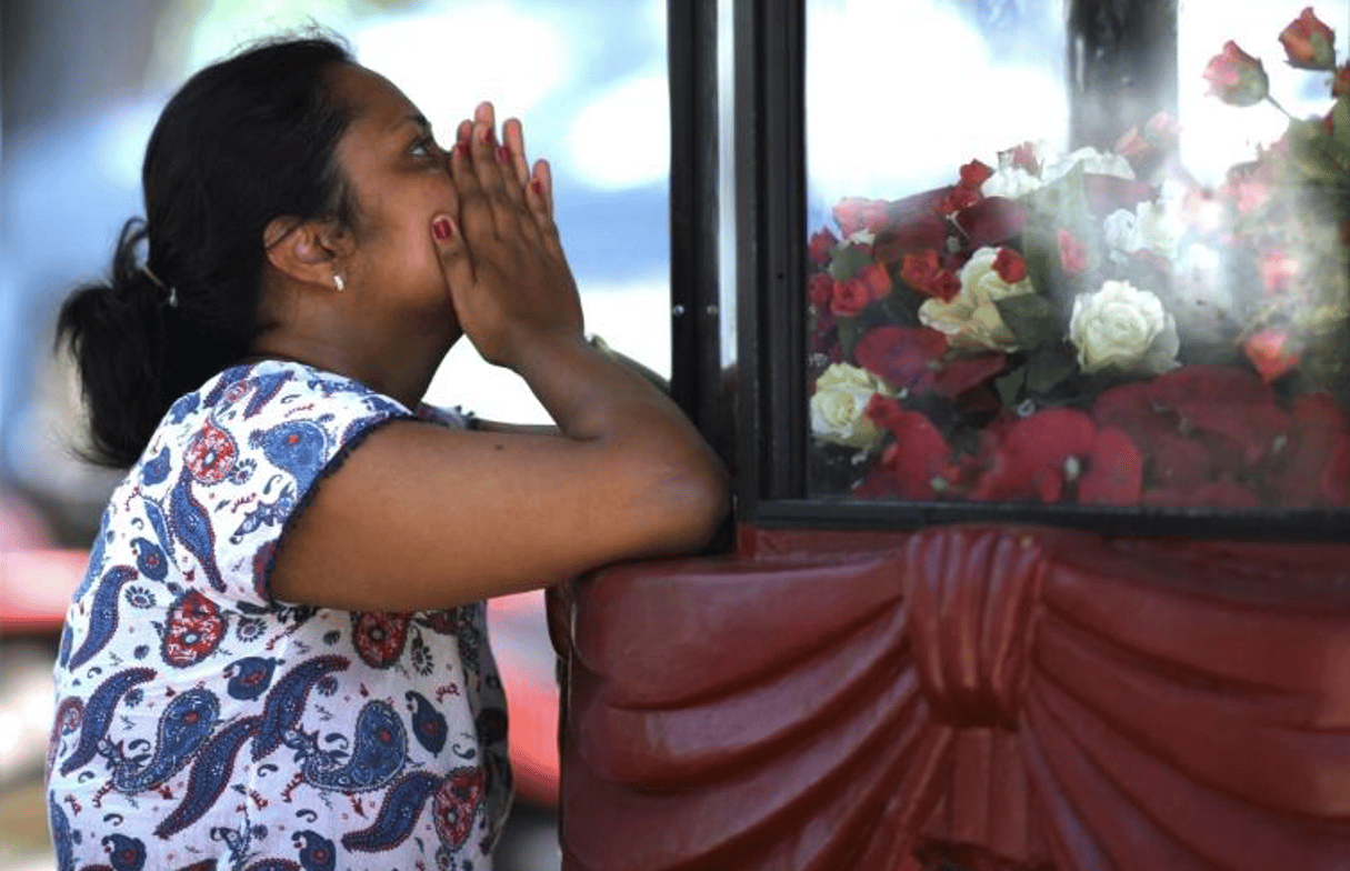 Une femme prie devant l’église Saint-Sebastien à Negombo, le 22 avril 2019, au lendemain des explosions meurtrières. © Jewel SAMAD/AFP