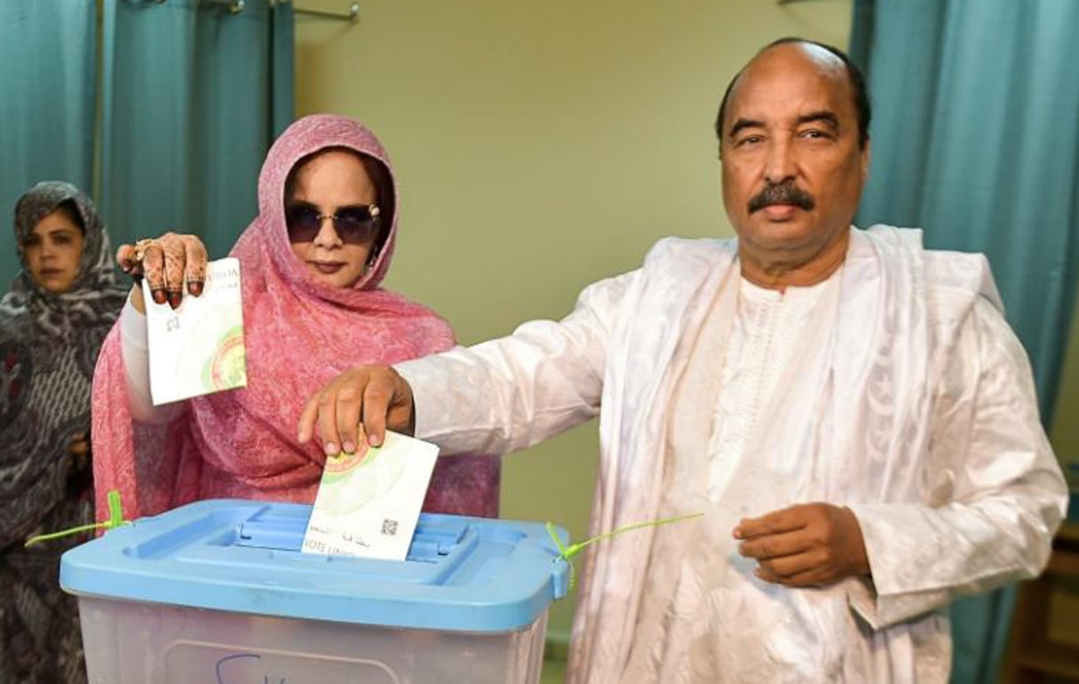 Le président mauritanien Mohamed Ould Abdelaziz vote pour l’élection de son successeur au côté de son épouse, le 22 juin 2019 à Nouakchott. © SIA KAMBOU/AFP