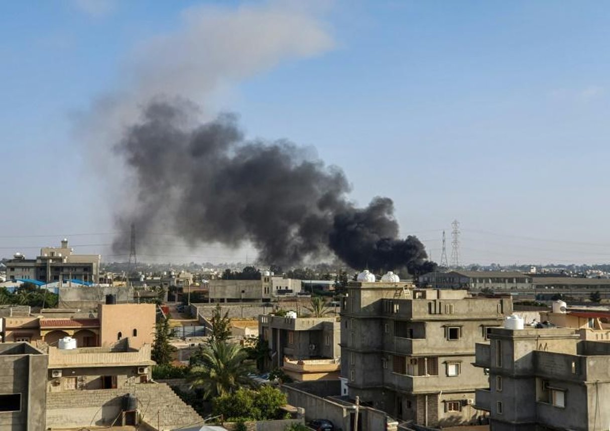 Une colonne de fumée s’élève à Tajoura, au sud de Tripoli (Libye), après une frappe aérienne, le 29 juin 2019. © Mahmud TURKIA/AFP