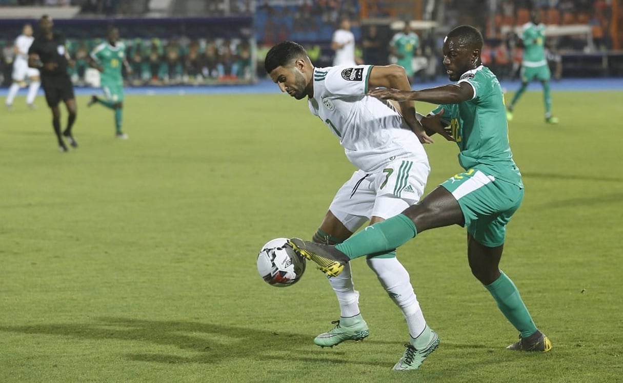 L’Algérien Riyad Mahrez dispute le ballon au Sénégalais Youssouf Sabaly en finale de la CAN 2019, le 19 juillet 2019 au Caire. © AP Photo/Amr Nabil