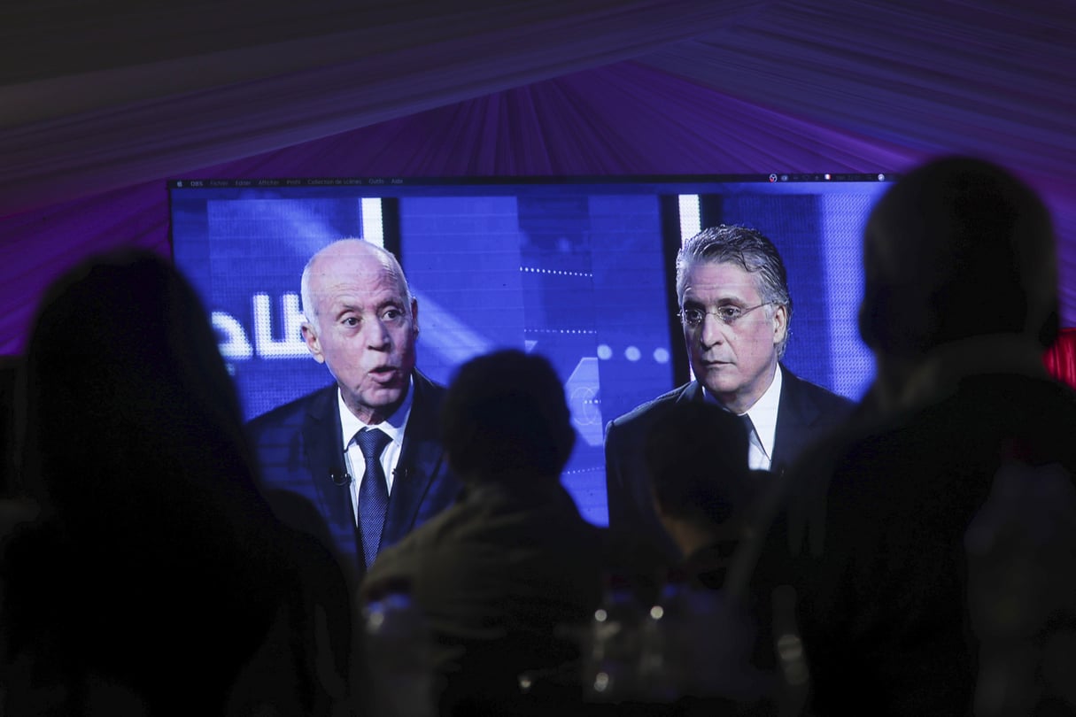 Des Tunisiens regardent le débat télévise entre Kaïs Saïed (gauche) et Nabil Karoui, avant le second tour de dimanche 13 octobre. © Mosa’ab Elshamy/AP/Sipa