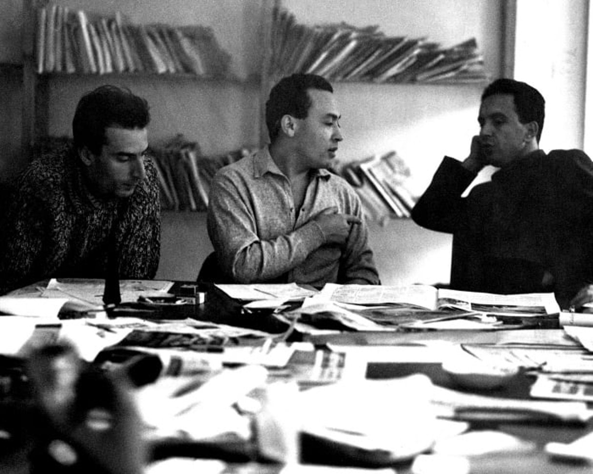 Le fondateur de Jeune Afrique, Béchir Ben Yahmed, entre Guy Sitbon (à gauche) et Mohamed Ben Smaïl (à droite), dans la salle de rédaction d’Afrique Action à Tunis, l’été 1960. © Archives Jeune Afrique-REA
