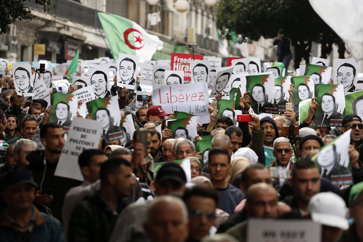 Des manifestants portent des photos de détenus politiques dans les rues d’Alger pour rejeter l’élection présidentielle et protester contre le gouvernement, le 27 décembre 2019. © Toufik Doudou/AP/SIPA