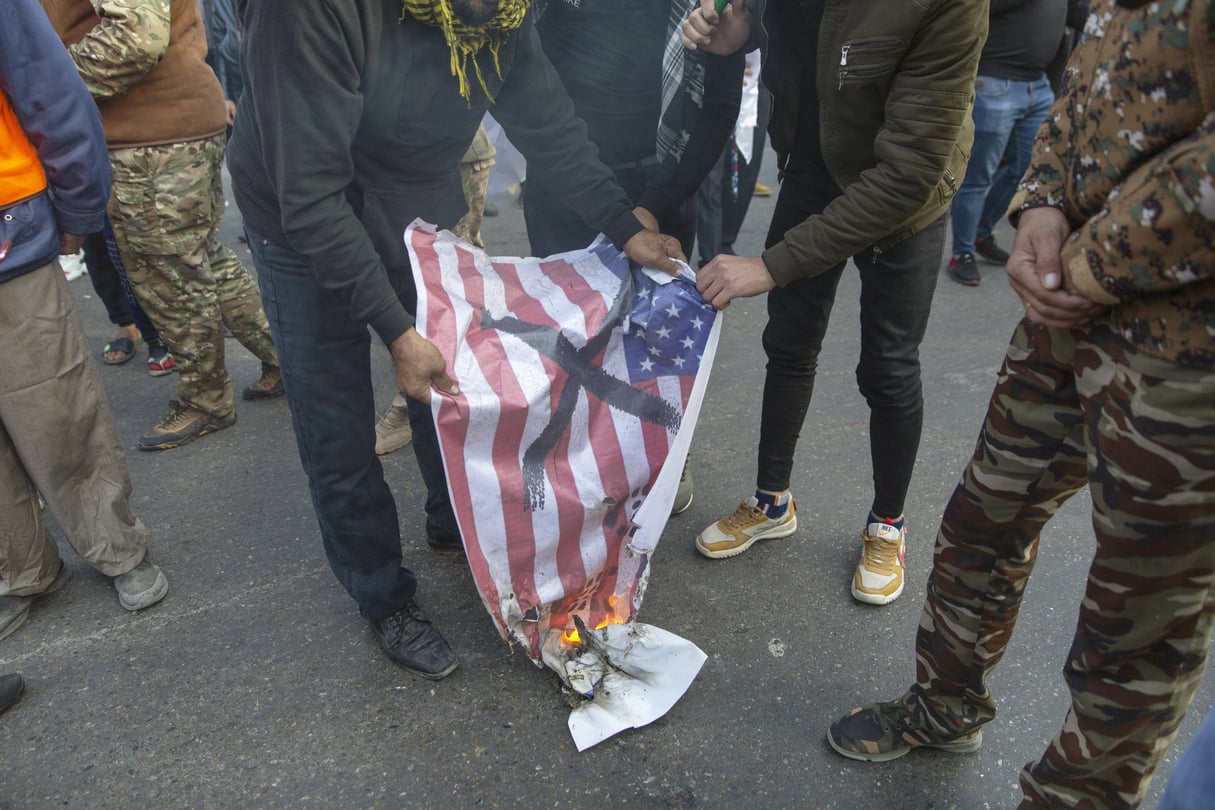 Lors des funérailles du général Qassem Soleimani, un drapeau américain brûle, le 4 janvier 2020 à Baghdad, en Irak. &copy; Nasser Nasser/AP/Sipa