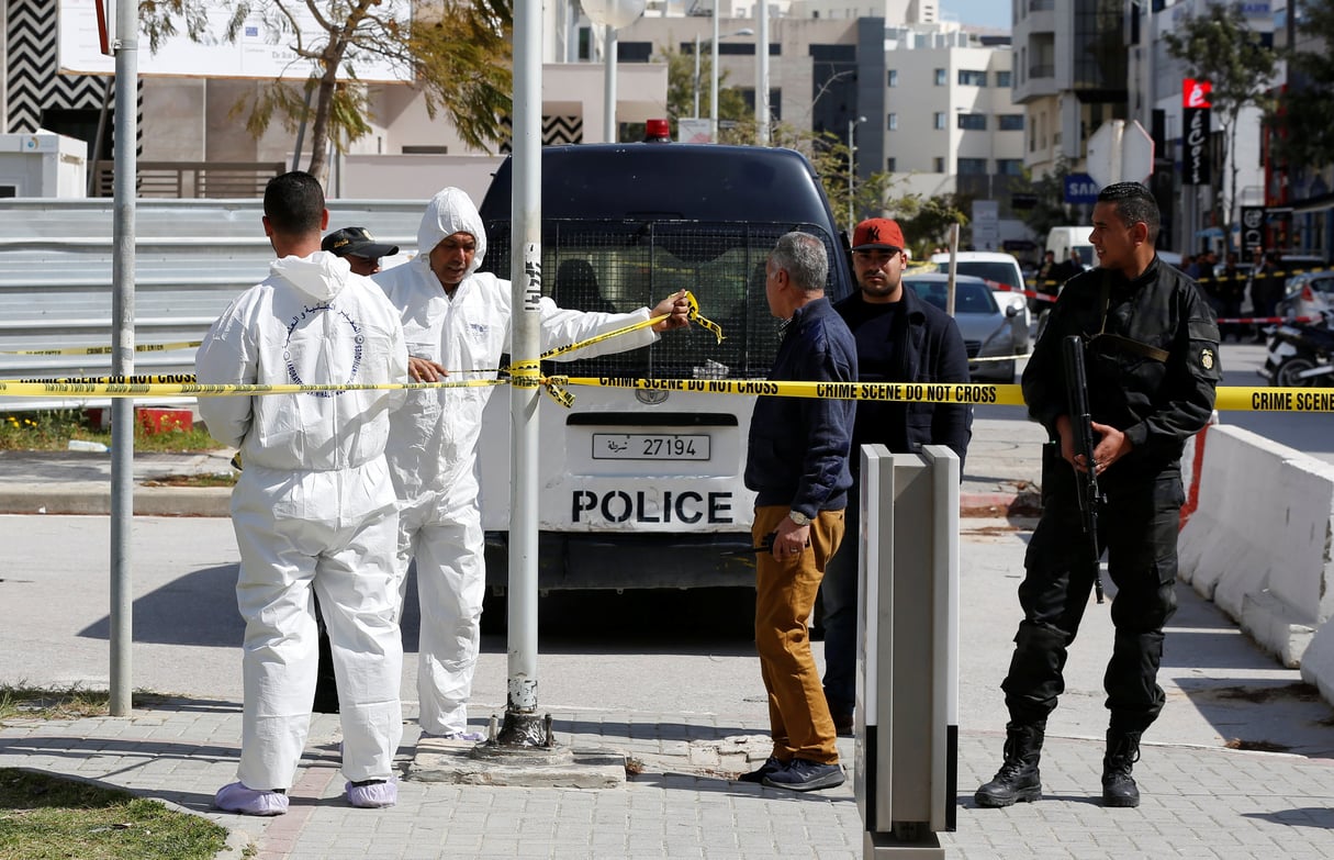 Les experts de la police scientifique et les forces de sécurité tunisiennes sur le lieu de l’attaque qui a visé l’ambassade américaine le 6 mars 2020. © REUTERS/Zoubeir Souissi