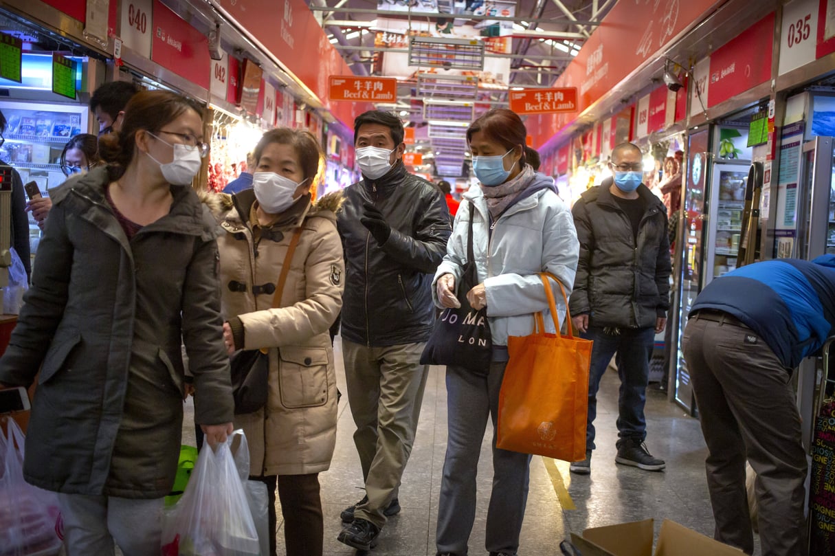 Des gens portent des masques pour faire leurs courses dans un marché de Pékin, le samedi 14 mars 2020. &copy; Mark Schiefelbein/AP/SIPA