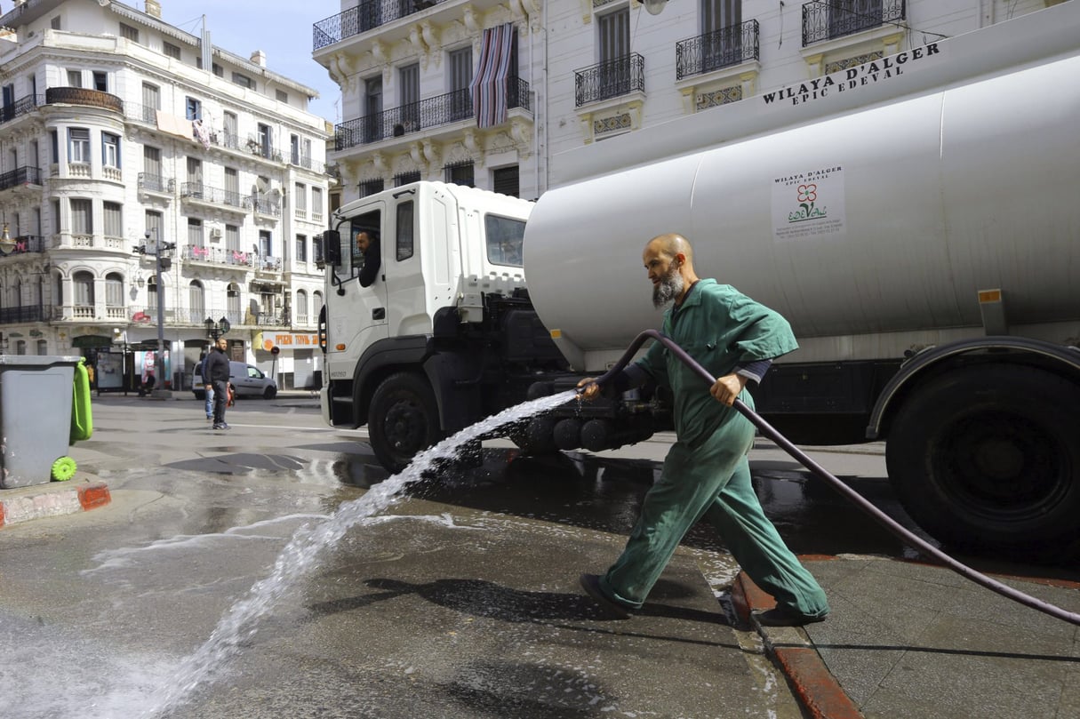 Un homme désinfecte les rues d’Alger, le 22 mars 2020. © Anis Belghoul/AP/SIPA