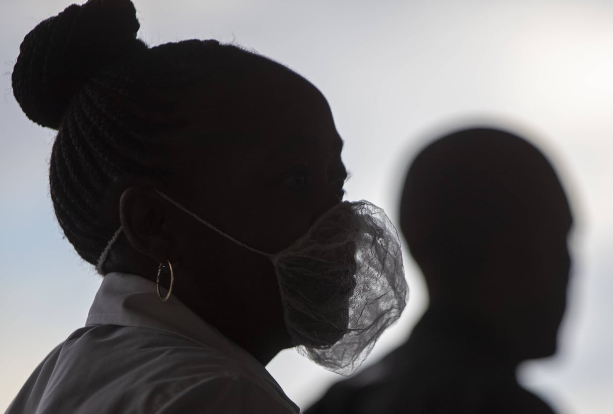 Une femme porte un masque pour se protéger du coronavirus à l’extérieur d’un supermarché, à Soweto, en Afrique du Sud, le 26 mars 2020 (photo d’illustration). © Themba Hadebe/AP/Sipa