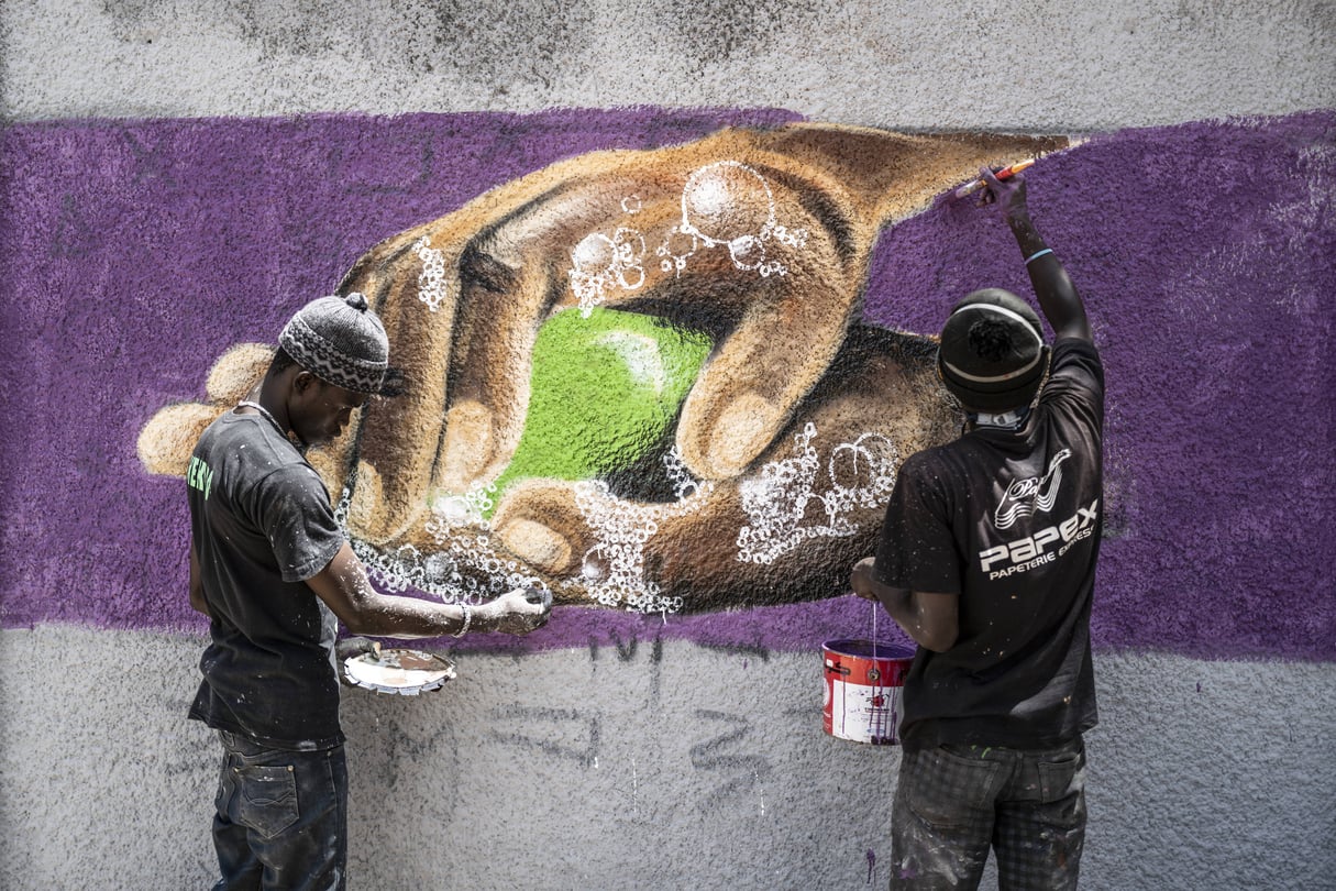 Des graffeurs réalisent une fresque incitant à la prévention face au coronavirus, dans une rue de Dakar, le 25 mars 2020. © Sylvain Cherkaoui/AP/SIPA