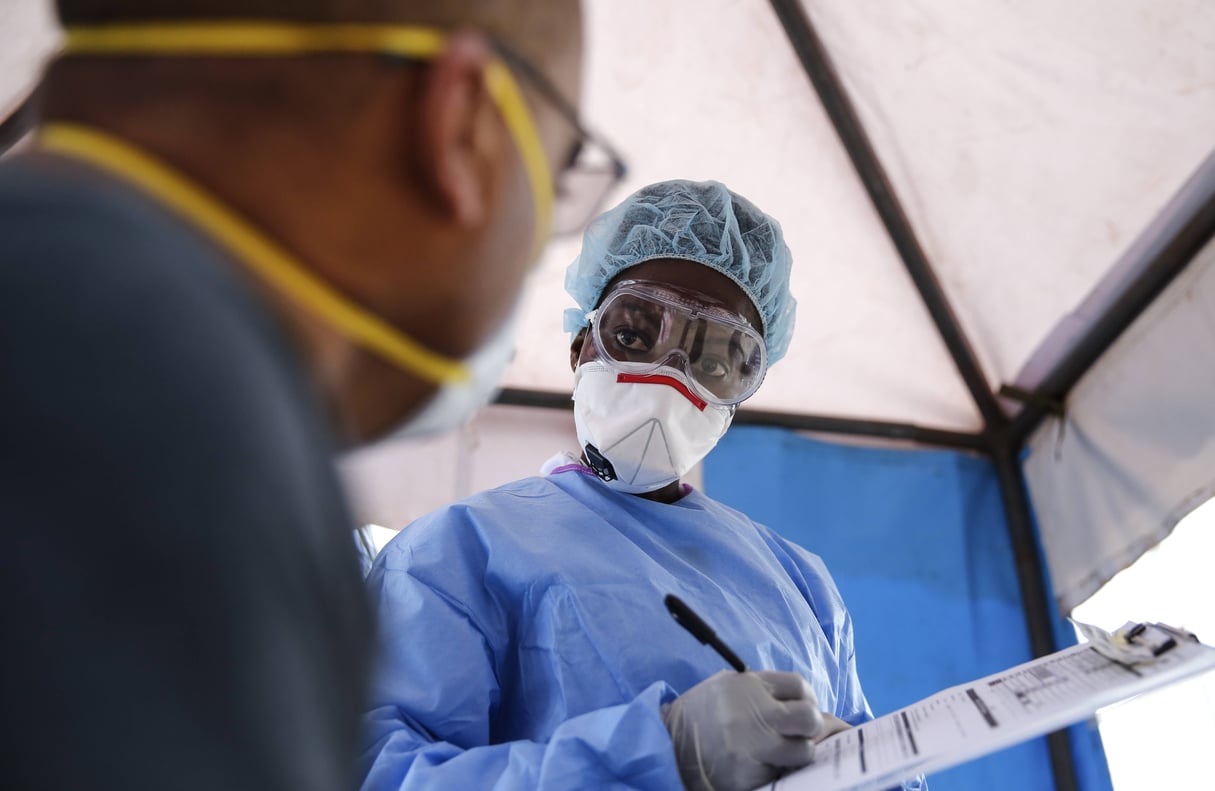 Un patient sur le point de se faire tester au Covid-19 face à une membre de l’équipe médicale à Nairobi, au Kenya, le 5 avril 2020. © AP Photo / Brian Inganga
