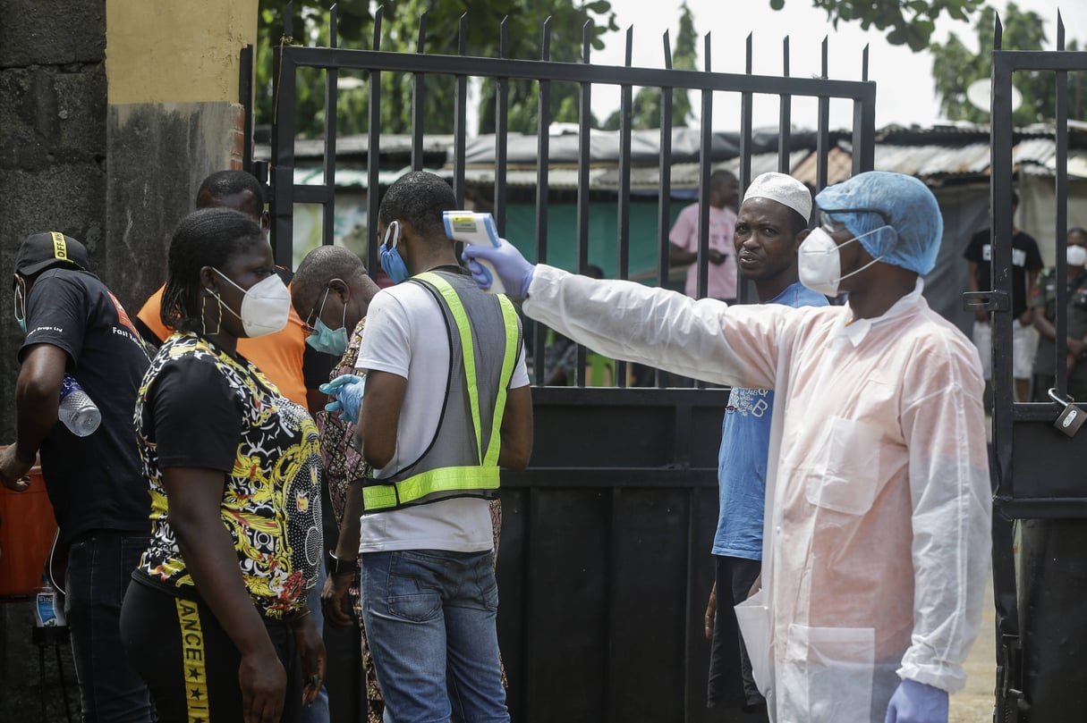 Un responsable de la santé prend la température d’un patient qui cherche à être testé, à Lagos, au Nigeria, le 23 avril. © Sunday Alamba/AP/SIPA