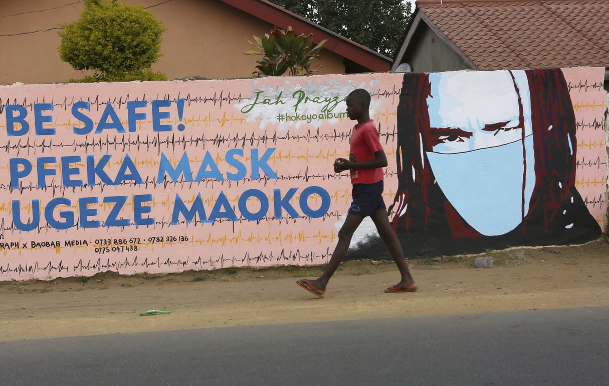 Un jeune garçon passe devant un mur avec des graffitis exhortant les gens à porter des masques à Harare, au Zimbabwe, le 28 mai 2020. © Tsvangirayi Mukwazhi/AP/SIPA