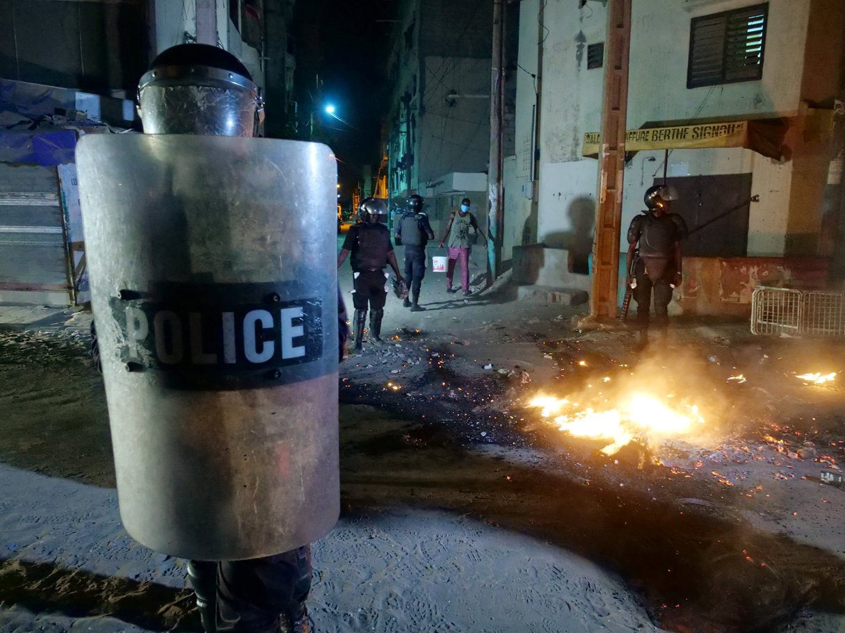 Des policiers anti-émeutes dans une rue de Dakar où des échauffourées ont éclaté dans la nuit de mardi 3 à mercredi 4 lors de manifestations contre le couvre-feu. © REUTERS/Christophe Van Der Perre