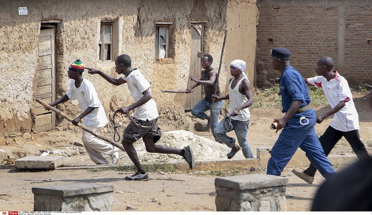 Des Imbonerakure pourchassent des manifestants de l’opposition, sans en être empêchés par les forces de l’ordre, à Bujumbura, le 25 mai 2015 Members of the Imbonerakure pro-government youth militia chase after opposition protesters, unhindered by police, in the Kinama district of the capital Bujumbura, in Burundi Monday, May 25, 2015. Protests continued in the capital Monday, with demonstrators saying they will continue until President Pierre Nkurunziza steps down at the end of his second term. 
© Berthier Mugiraneza/AP/SIPA