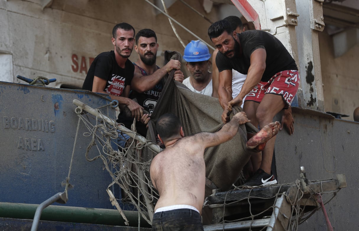 Lebanon Explosion © Civilians help to evacuate an injured sailor from a ship which dock near the explosion scene that hit the seaport of Beirut, Lebanon, Tuesday, Aug. 4, 2020. Massive explosions rocked downtown Beirut on Tuesday, flattening much of the port, damaging buildings and blowing out windows and doors as a giant mushroom cloud rose above the capital. (AP Photo/Hussein Malla)/XHM132/20217654740109//2008042013