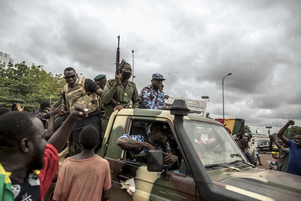 Des manifestants saluent le passage un convoi de militaires à Bamako, le 19 août 2020, au lendemain de la démission d’IBK. © /AP/SIPA