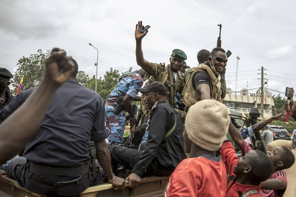 Des soldats maliens salués par la foule sur la place de l'Indépendance, le 19 août 2020, quelques heures après la démission du président IBK. &copy; /AP/SIPA