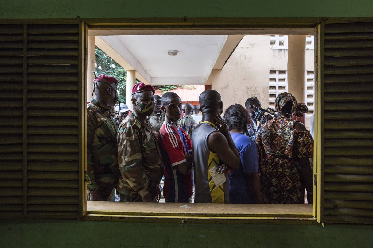 Des civils et des soldats font la queue pour voter à Conakry, à l’occasion du premier tour de l’élection présidentielle, le 18 octobre 2020. © Sadak Souici/AP/Sipa