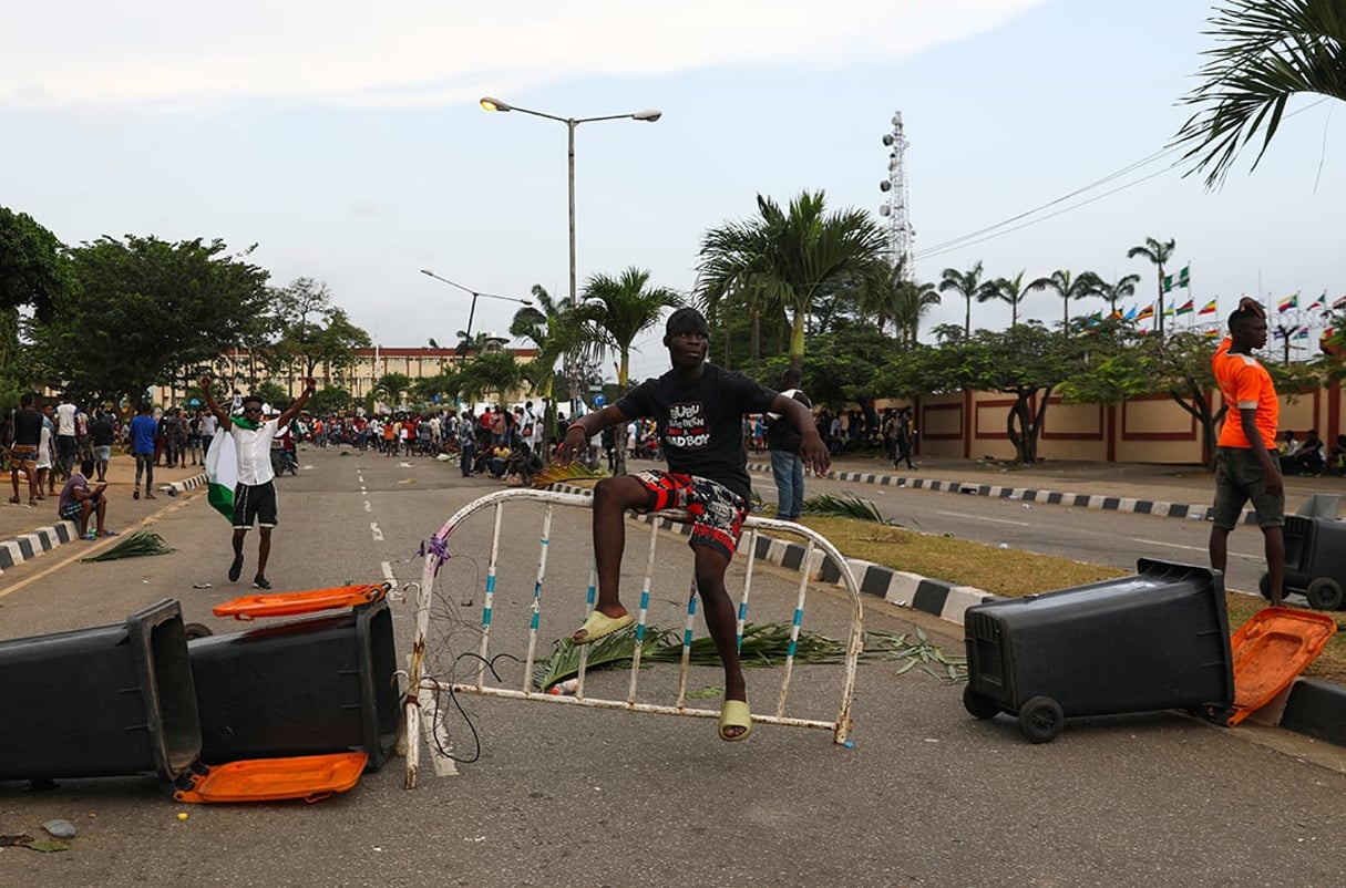 Un manifestant est assis sur une barricade bloquant une route près de l’Assemblée de Lagos, le 20 octobre 2020. A demonstrator sits on a barricade blocking a road near the Lagos State House, despite a round-the-clock curfew imposed by the authorities on the Nigerian state of Lagos in response to protests against alleged police brutality, Nigeria October 20, 2020.
© Temilade Adelaja/REUTERS