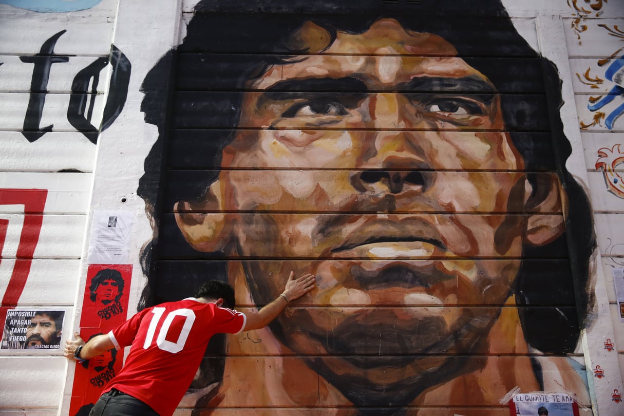 Un supporter se recueille devant une fresque de Maradona, en Argentine, le 25 novembre 2020. © Marcos Brindicci/AP/SIPA