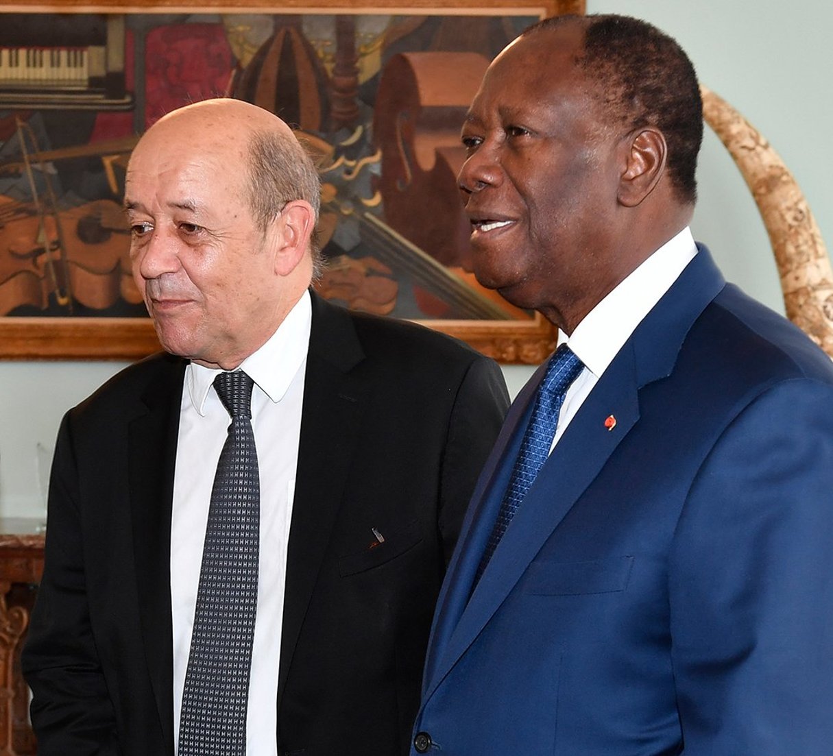 Jean-Yves Le Drian et Alassane Ouattara, en 2018. France’s Minister for Foreign Affairs Jean-Yves Le Drian (L) stands past Ivory Coast’s President Alassane Ouattara upon his arrival at the presidential palace in Abidjan on October 18, 2018. 
© ISSOUF SANOGO/AFP