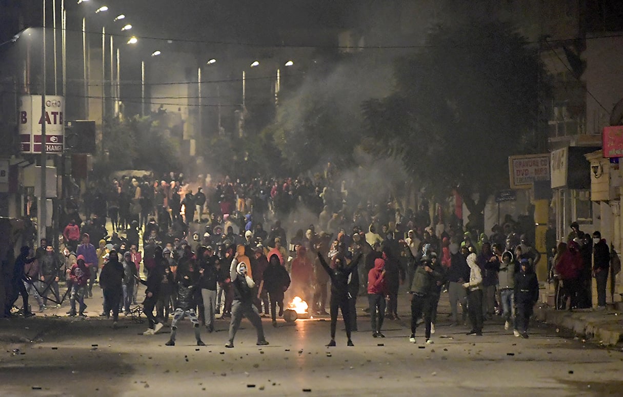 Des manifestants bloquent une rue lors des affrontements avec les forces de sécurité dans la banlieue d’Ettadhamen, dans la banlieue nord-ouest de Tunis, le 18 janvier 2021. © FETHI BELAID/AFP