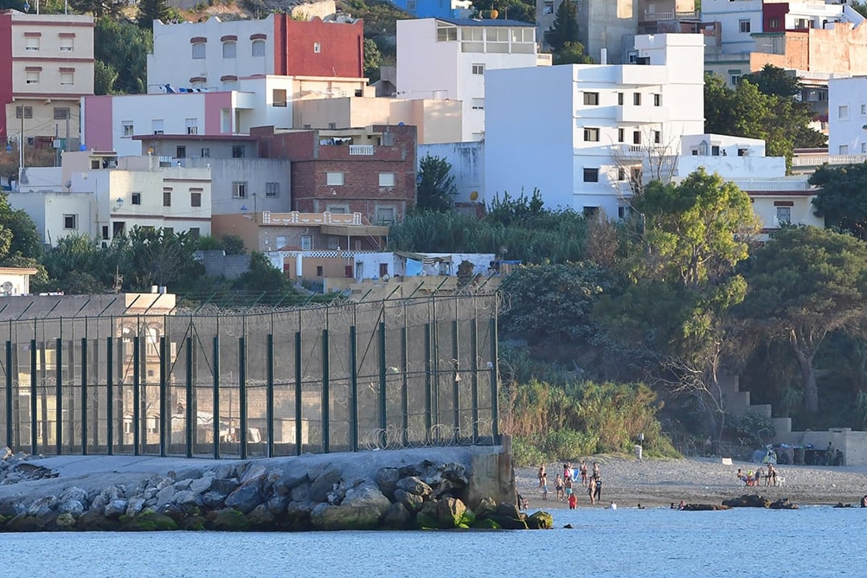 Des gens se baignent près de la clôture frontalière séparant l’esclave espagnol de Ceuta du Maroc, le 23 août 2018. © Alexander Koerner/Getty Images