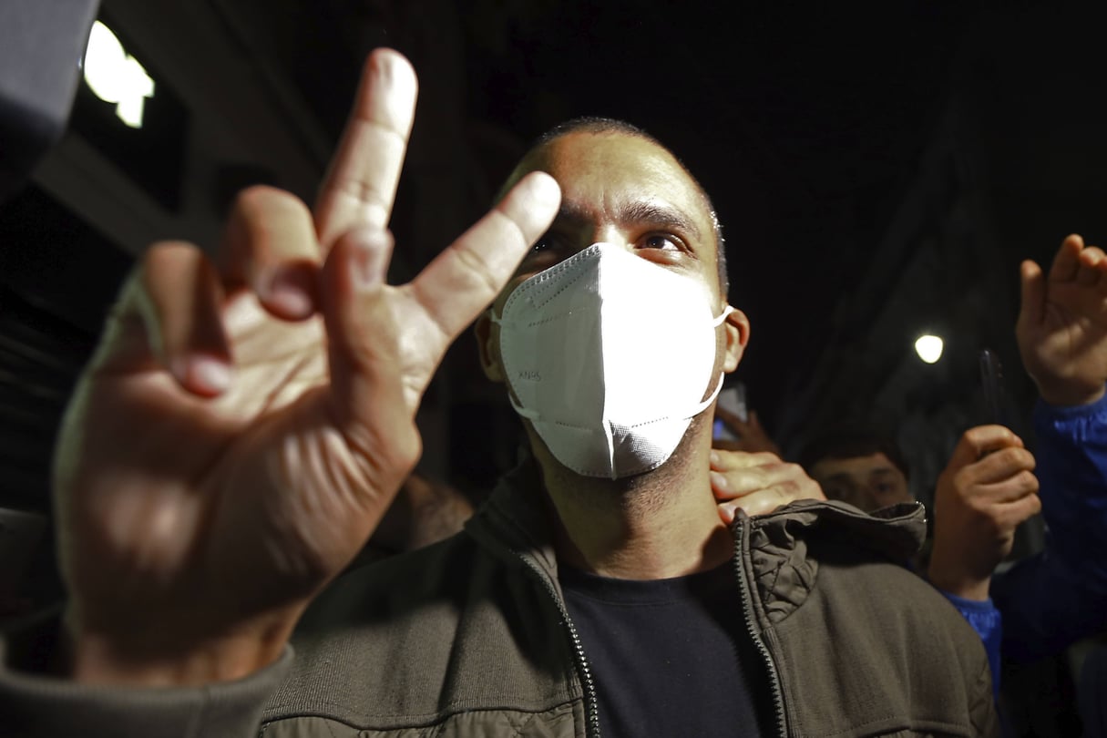 Khaled Drareni fait le V de la victoire après avoir été libéré de prison, à Alger, le 19 février 2021. © Fateh Guidoum/AP/Sipa
